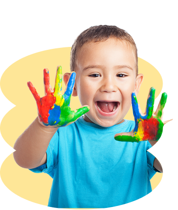 Niño en etapa de educación inicial mostrando sus manos pintadas de colores durante una actividad de aprendizaje creativo.